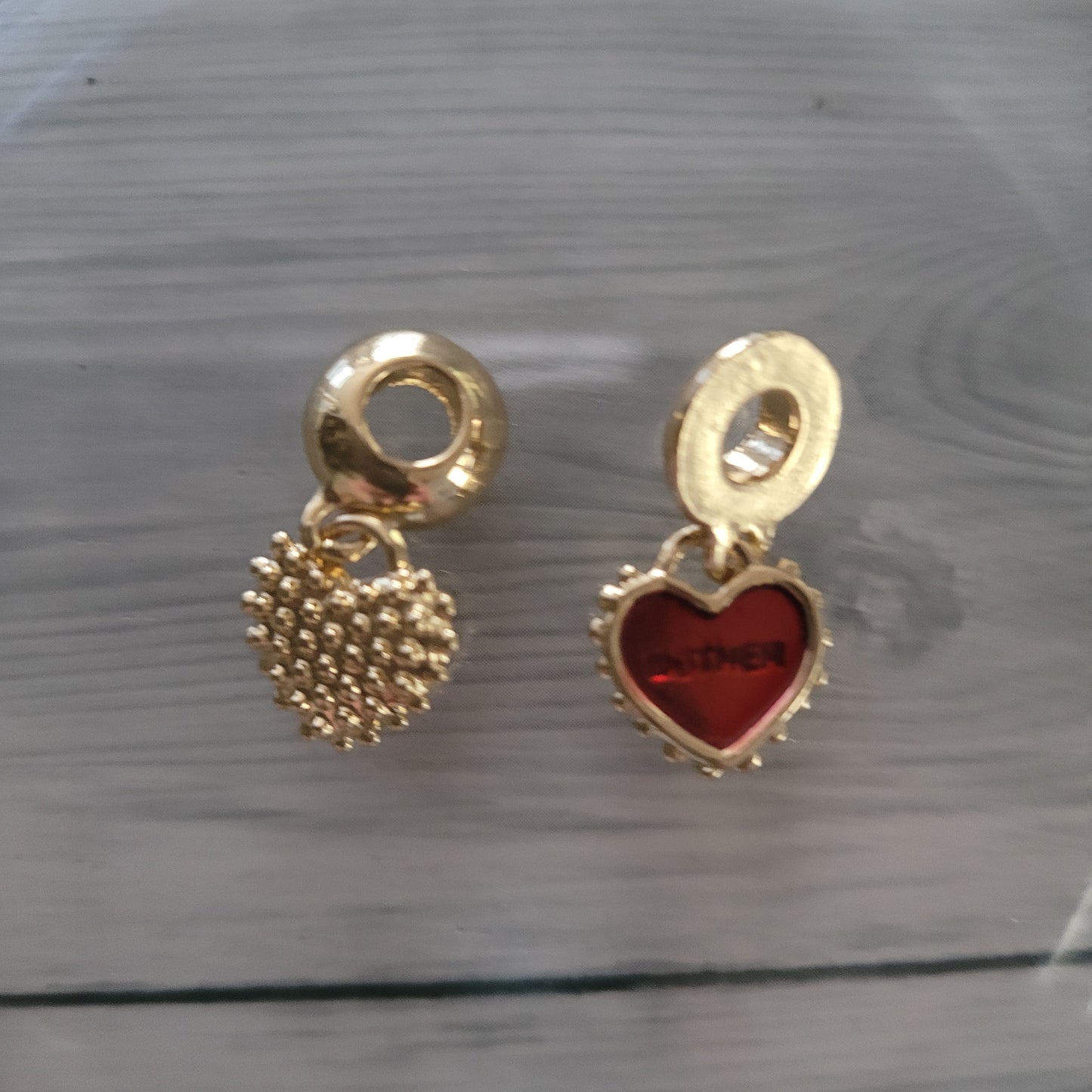 Charm. Gold metal heart with red inlay